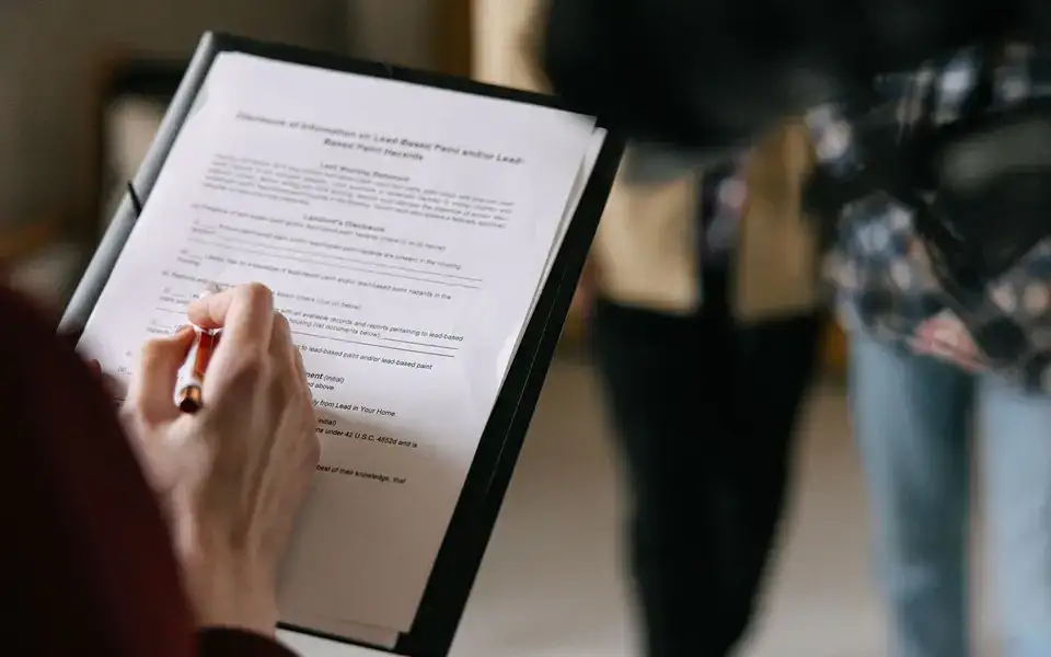 Pessoa conferindo documentos de um imóvel em uma prancheta